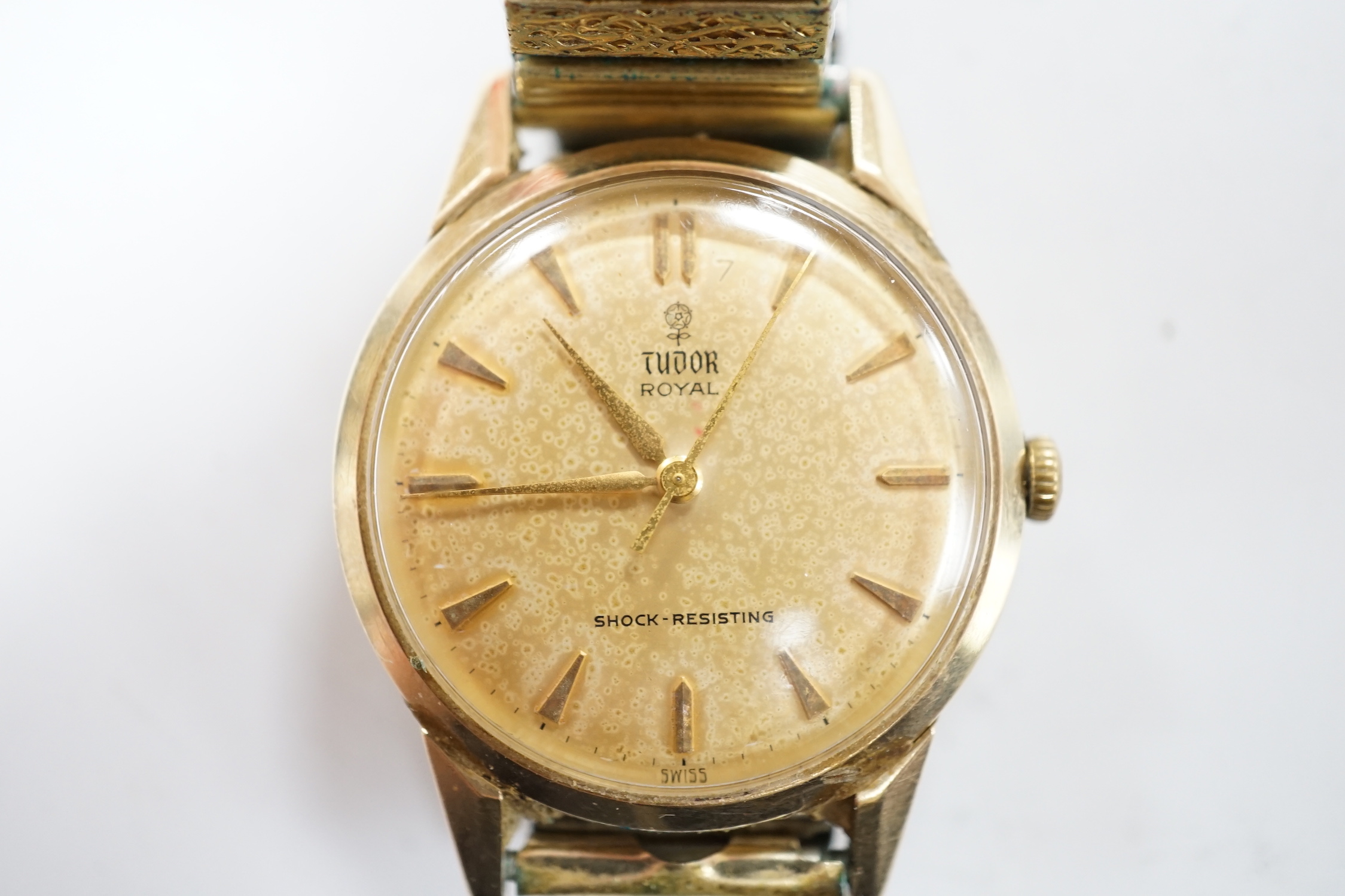 A gentleman's yellow metal Tudor Royal manual wind wrist watch, with baton numerals, on an associated flexible strap, with Tudor box.